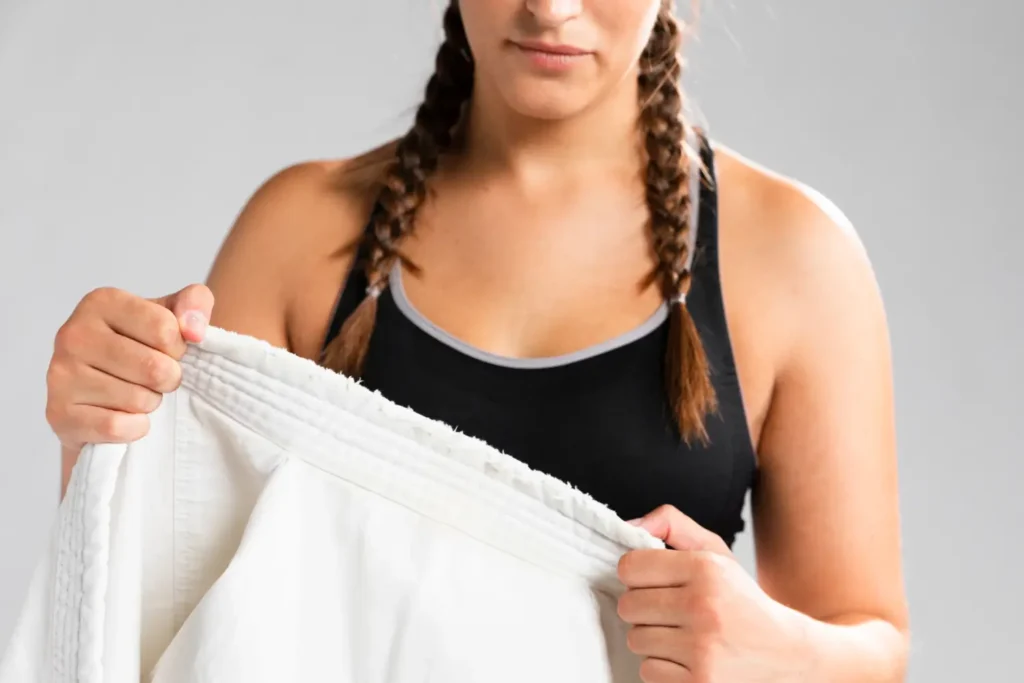 Mulher de tranças segurando uma calça de moletom com tecido elástico na cintura.