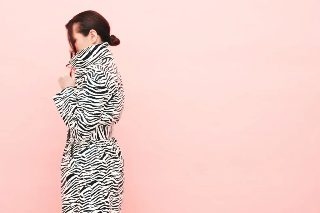 Modelo usando um casaco comprido com estampa animal print de zebra.