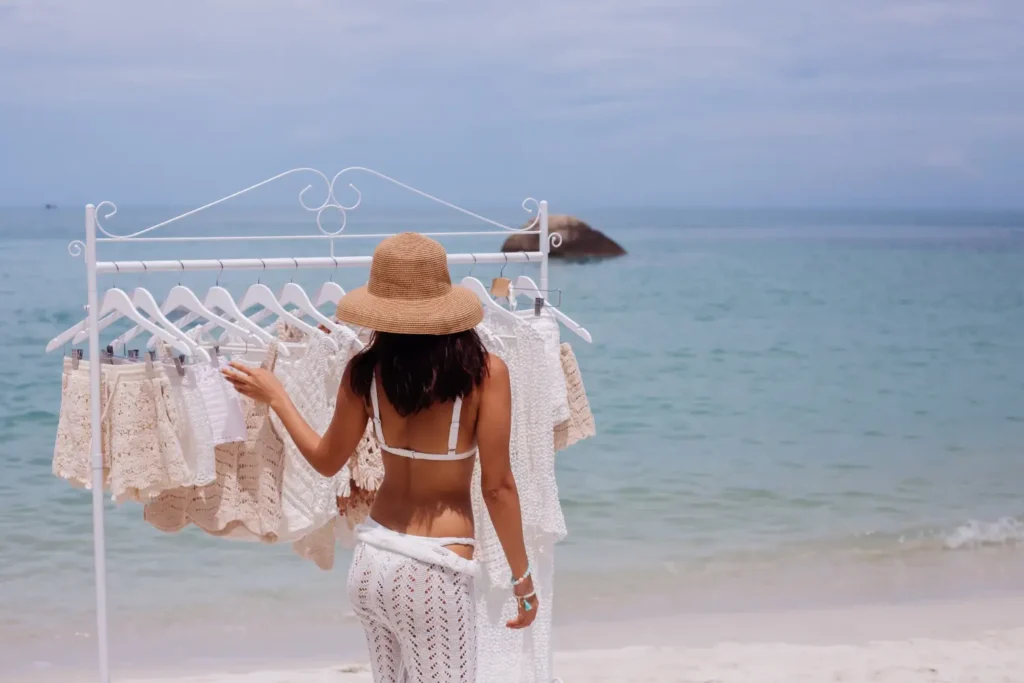 Mulher olhando para uma arara de roupas de moda praia