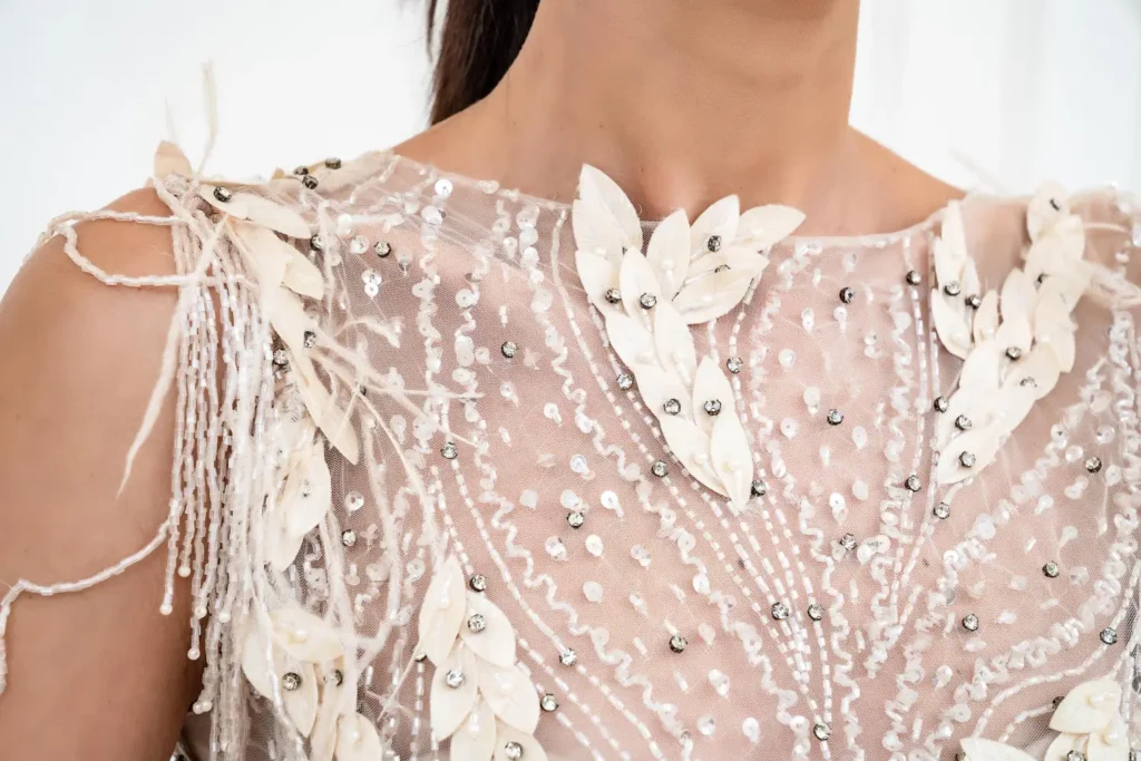 Roupa transparente com bordados, acessórios e ornamentos.