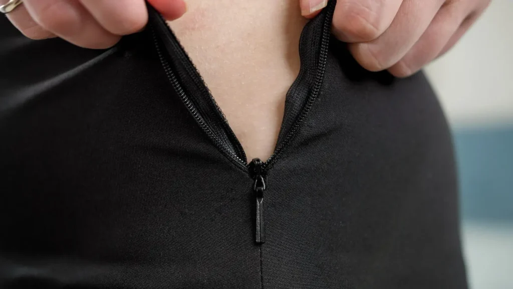 Zíper invisível aberto em uma peça de roupa de cor preta