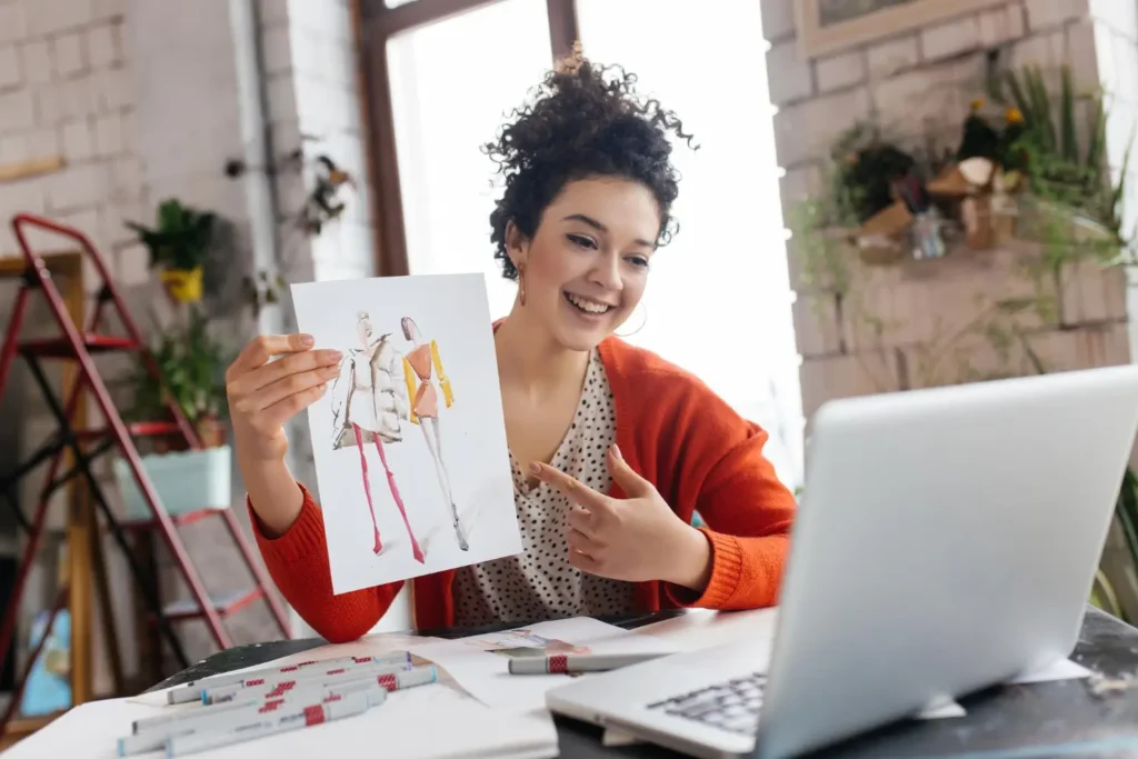 Estilista mostrando uma ilustração de moda para alguém em uma ligação de vídeo