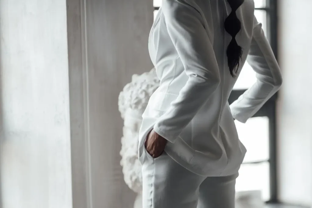 Modelo de costas usando um conjunto branco elegante, especialidade de uma maison.