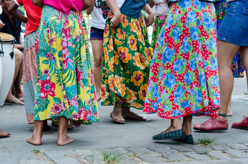 Mulheres com saias coloridas, floridas, feitas com tecido chita, na rua