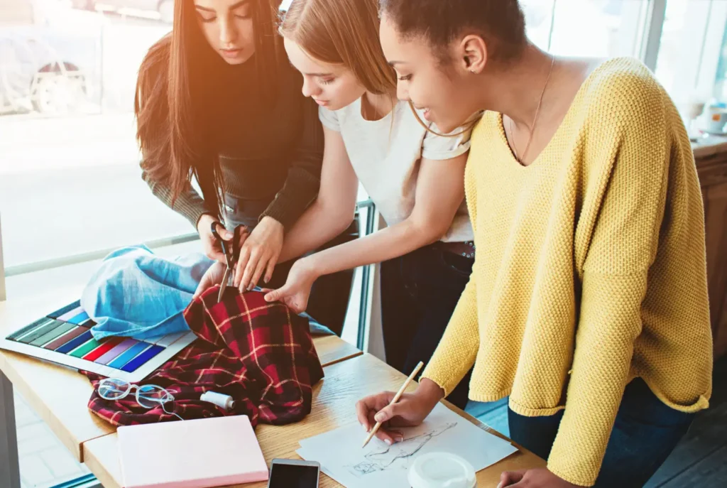 Estudantes de cursos de moda trabalhando em um projeto juntas