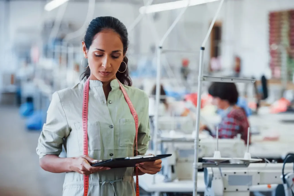 Mulher fazendo o controle de qualidade industrial em uma confecção