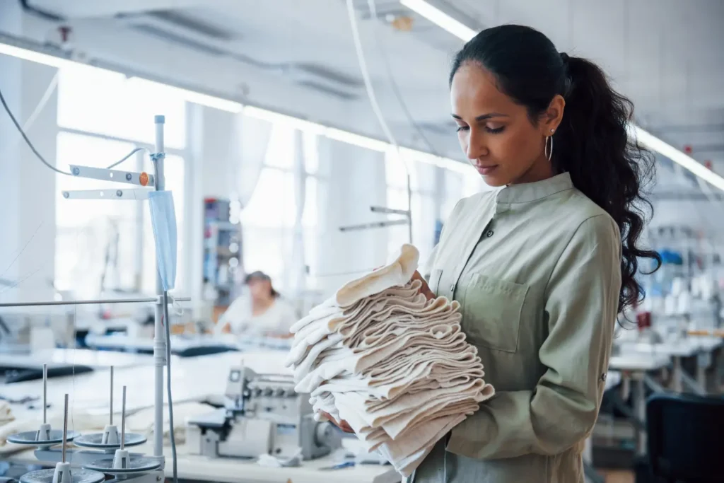 Mulher fazendo o controle de qualidade industrial têxtil