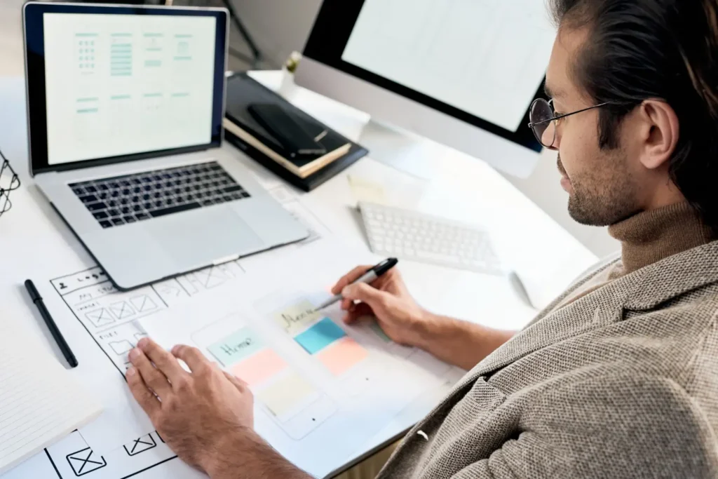 Homem com um planejamento bagunçado, cheio de folhas e processos manuais.