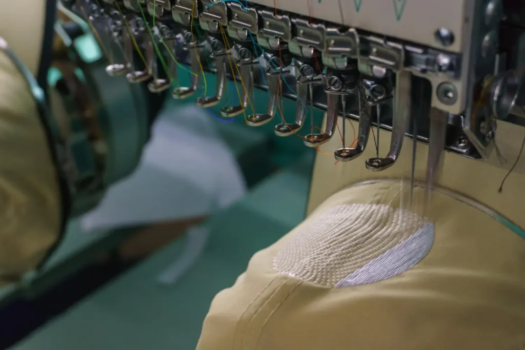 Bordado de um boné sendo feito à máquina, um dos diferentes tipos de bordados
