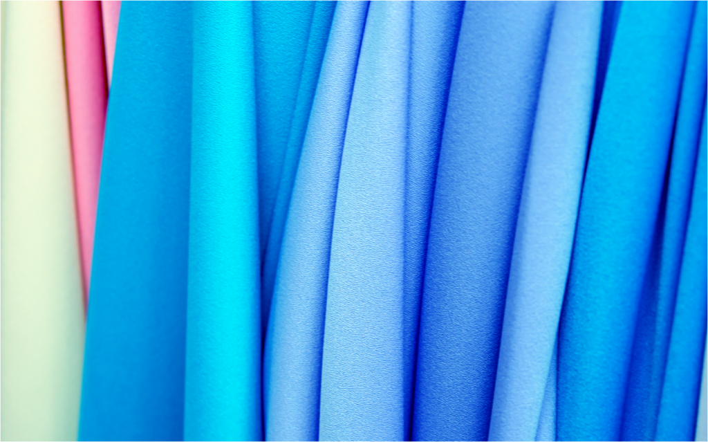 Stunning samples of colored crepe fabric, showcasing its fluid drape and textured surface.
