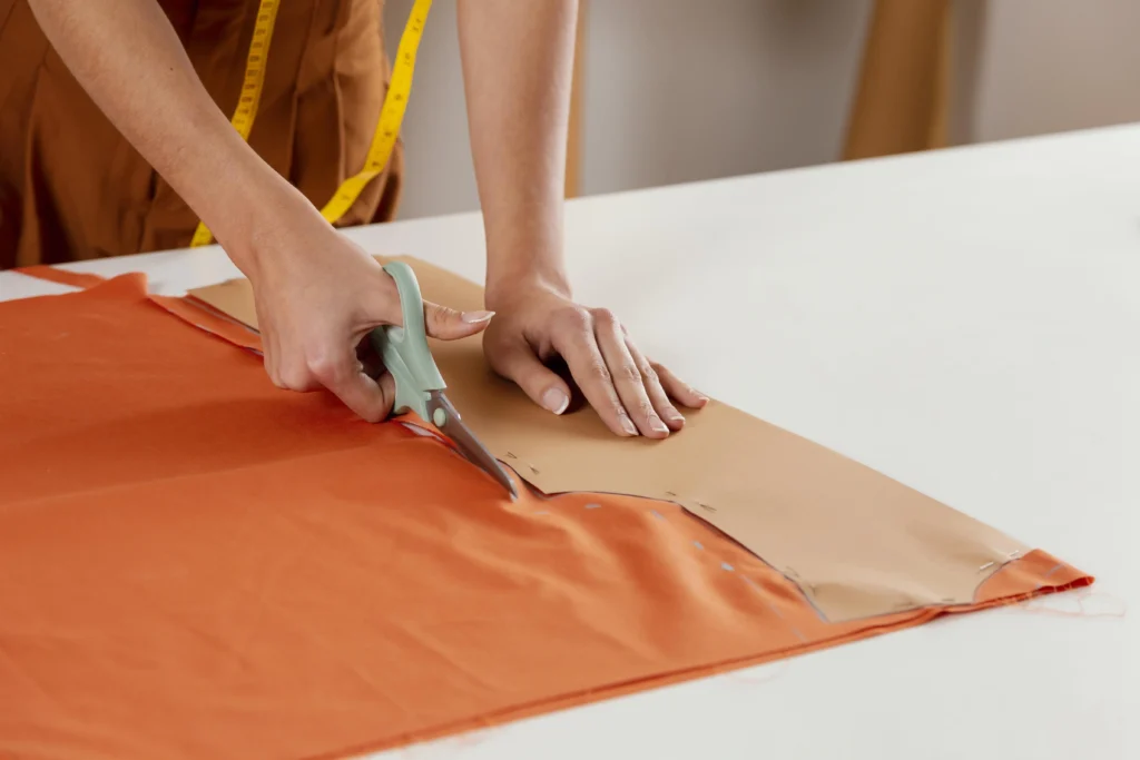A fashion designer cutting a piece of viscose fabric.