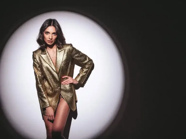 Young lady with sexy style wearing a shiny golden blazer.