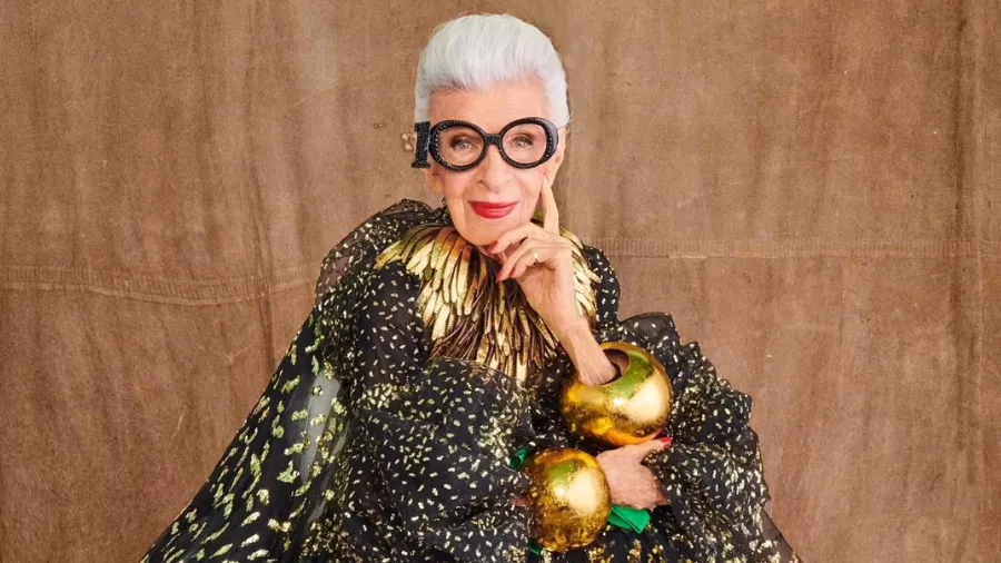 Iris Apfel usando um óculos de grau com o número "100", em comemoração aos seus 100 anos de idade.