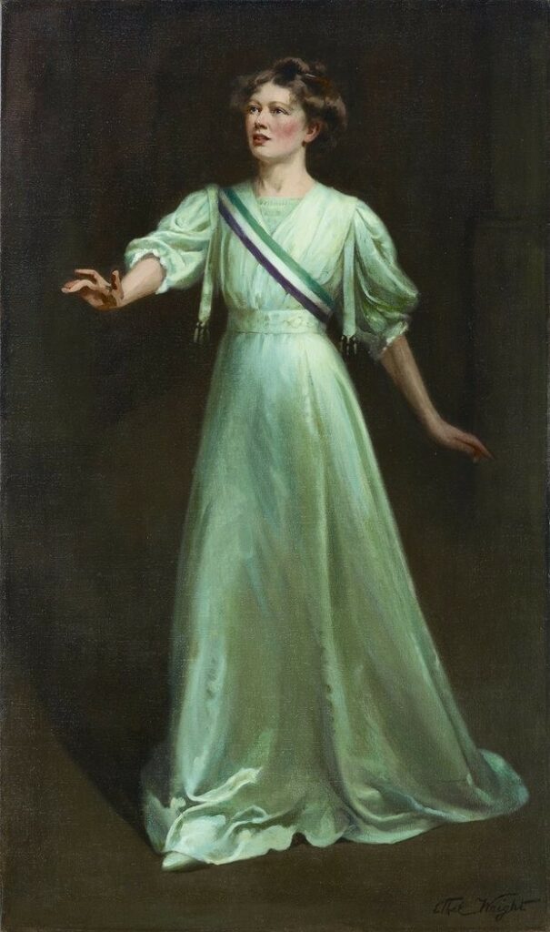 Suffragetta con fascia verde, bianca e rossa, simbolo del movimento femminista.  