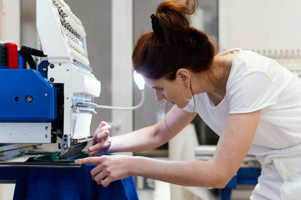 Dona de confecção com uma máquina de automatização industrial