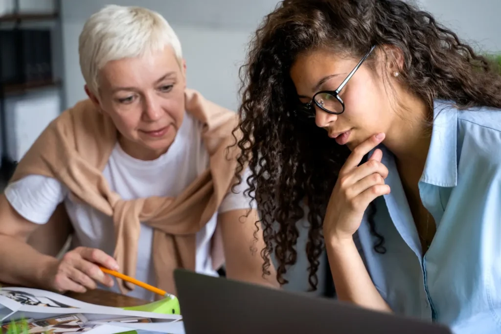 Empreendedorismo feminino. Duas mulheres colaborando e trabalhando juntas, concentradas em uma tarefa.