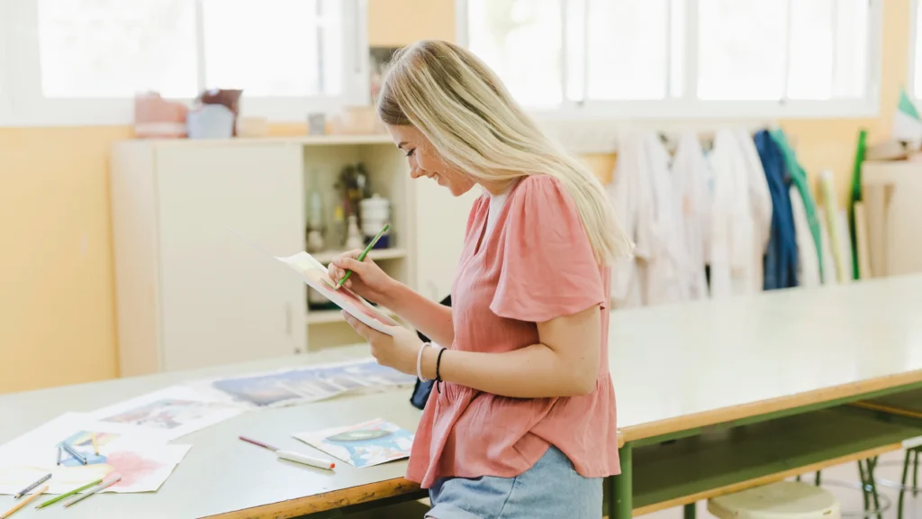 Dicionário de moda: mulher em seu ateliê lendo um panfleto