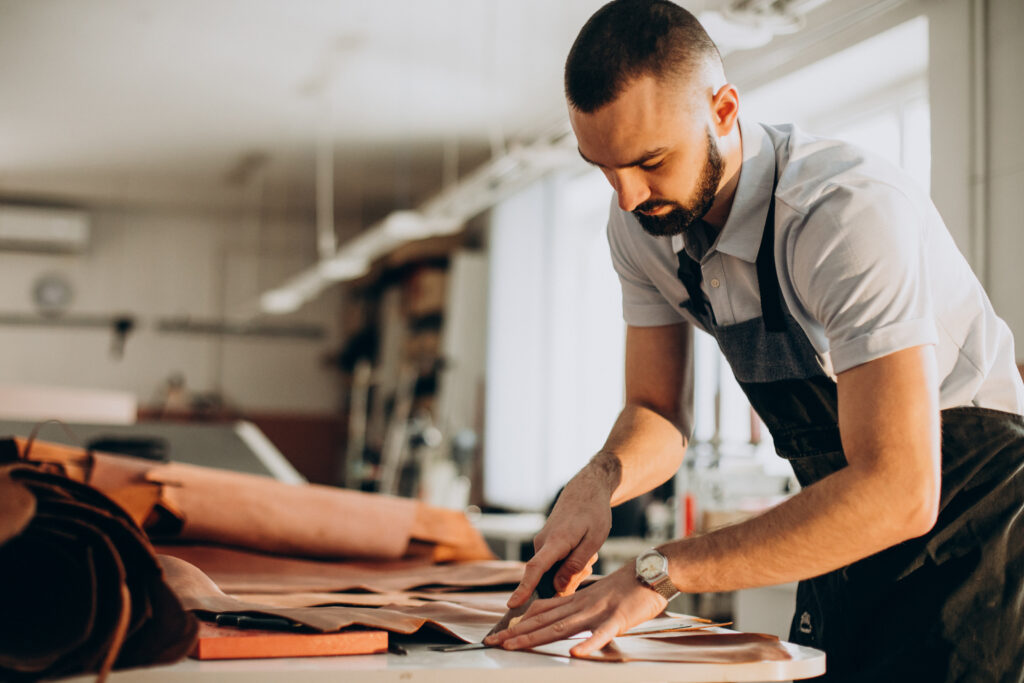 Male designer and tailor working on the textile processing of a fabric.