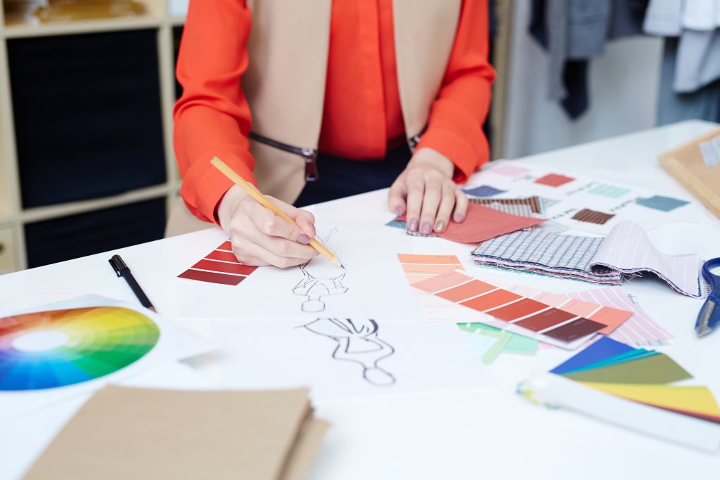 Chromatic circle: The image shows a dressmaker drawing sketches of new clothes.