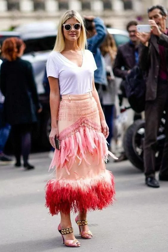 Woman wearing a skirt with feathers to watch the presentation of a Fall/Winter collection at a fashion show