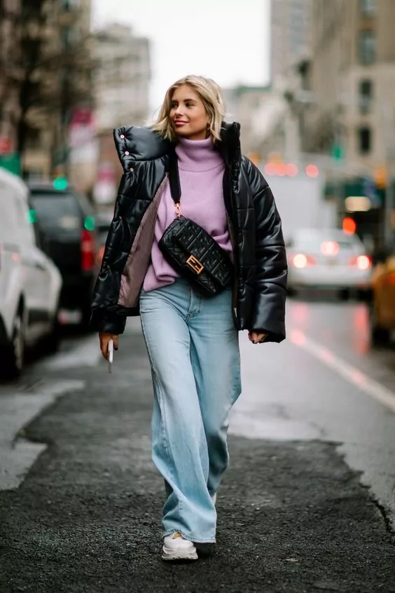 Woman with a puffer jacket and mom jeans showing an outfit with the Fall/Winter fashion trends
