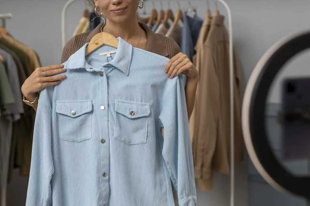 Perfect fit fabrics: Woman holding an item of clothing in front of a mirror to check if it will fit