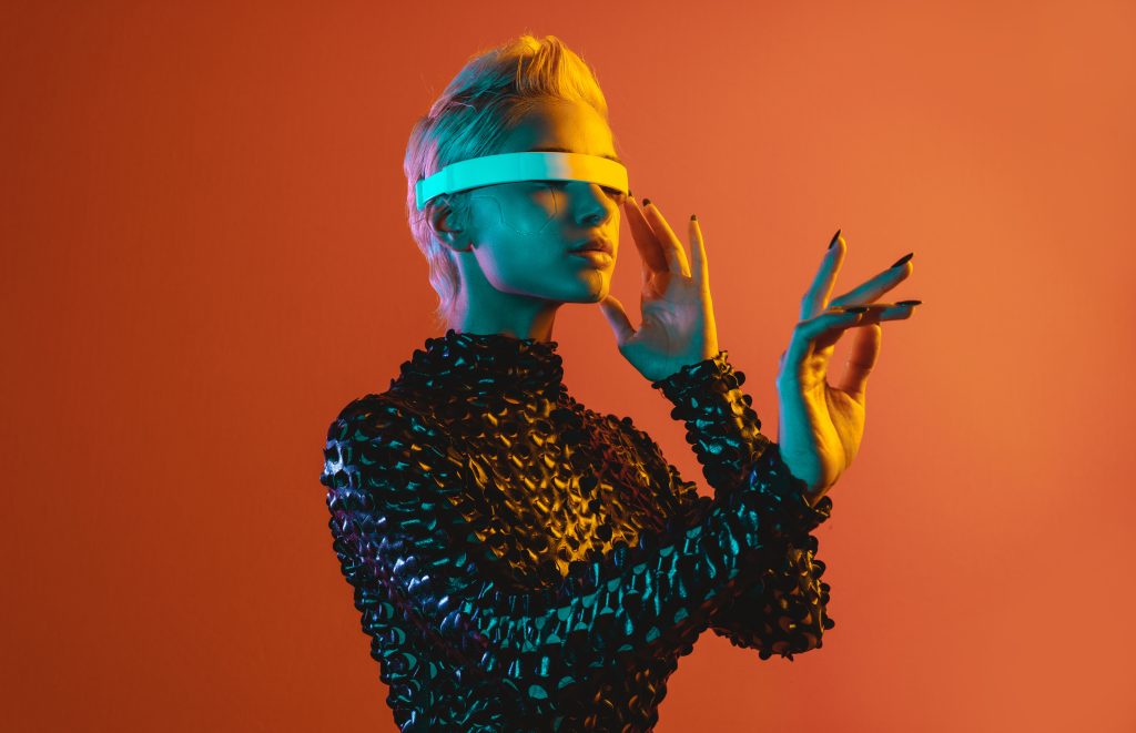 Futuristic fashion: Woman in a textured black outfit wearing technological glasses.