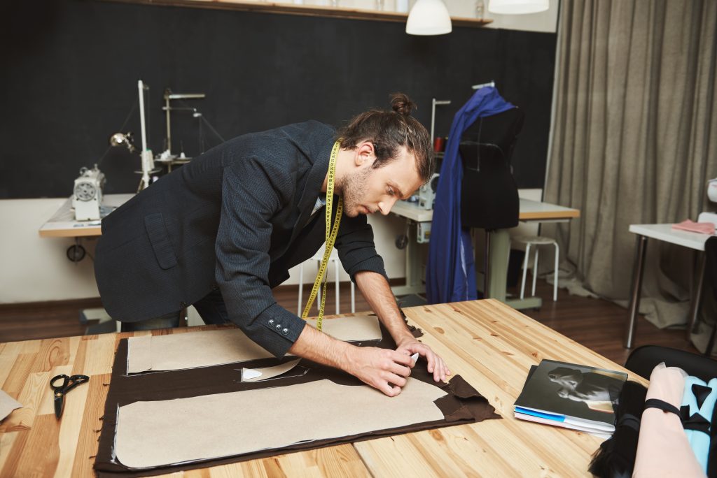 A male stylist designing a menswear pattern.