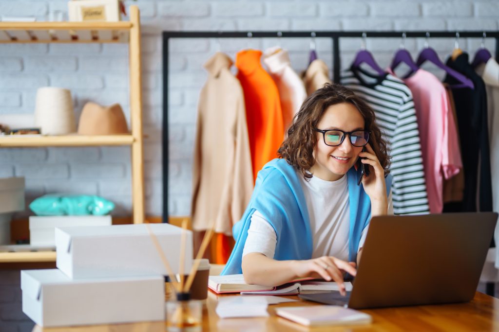 What is 3D modeling: woman using laptop in a clothing store.