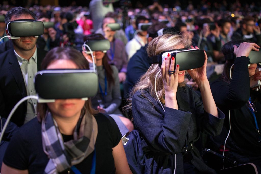 People in a conference audience using virtual reality headsets to visualize fashion creations.