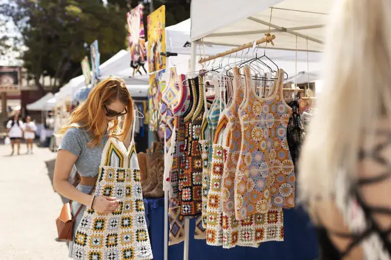 Ethical fashion: Woman tries on a handcrafted garment at a street fair.
