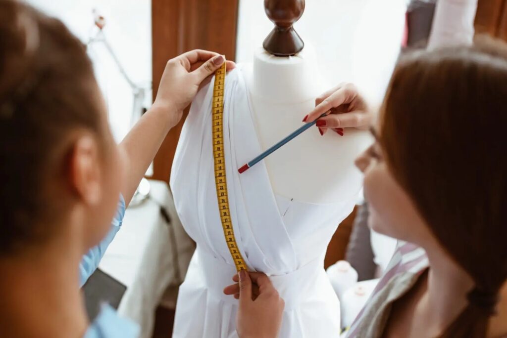 Close-up of taking measurements for new dress. Young fashion designer taking measurements for a wedding dress.
