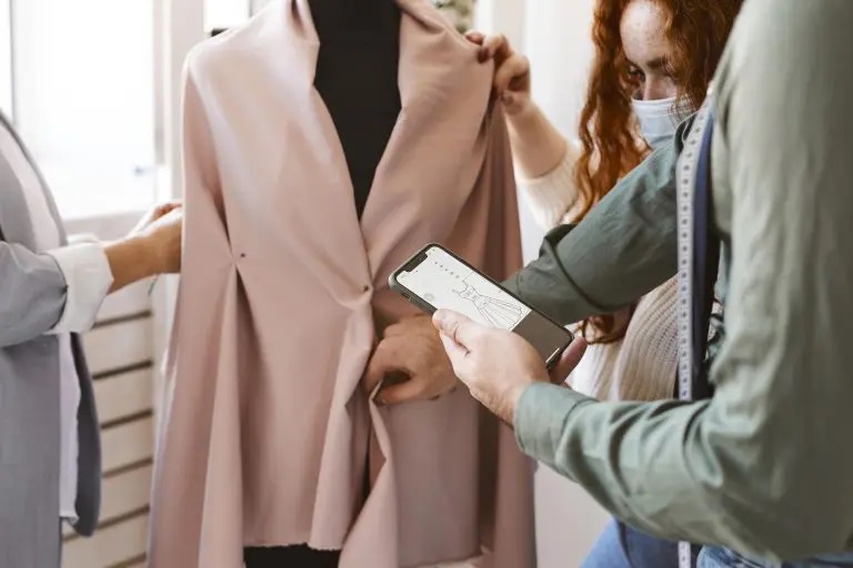 Pattern making: Fashion professionals checking the measurements of a sample garment on a mannequin.