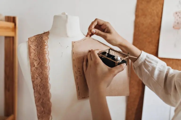 Pattern making: Female fashion designer preparing the pattern on a mannequin.