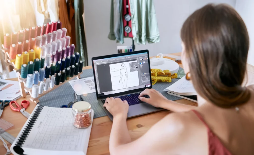 Mulher desenhando peça de roupa em notebook