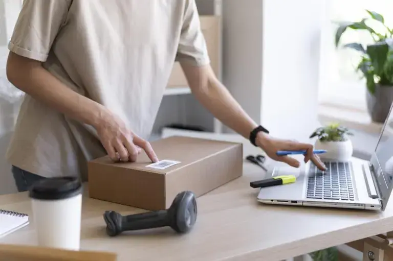 How to start an online fashion store:
Man checking barcodes on an order box in front of the computer.