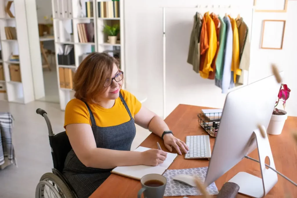 Plus-size fashion online: Young woman in wheelchair shopping online from her computer.