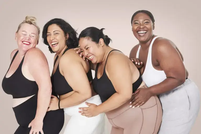 Plus-size fashion online: Four plus size women posing in a row in sportswear.