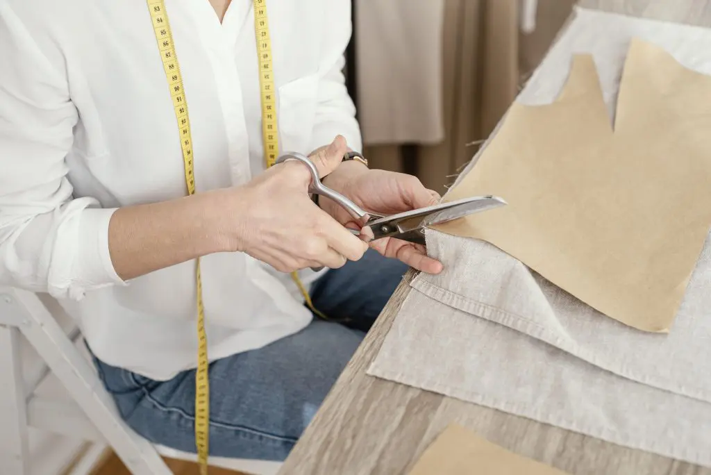 Fashion retail: Woman cutting and measuring a piece of fabric.