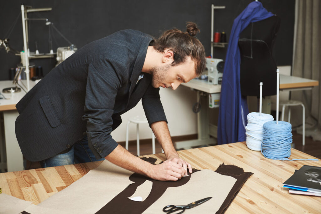 Homem criando peças de roupa utilizando moldes prontos para confecção