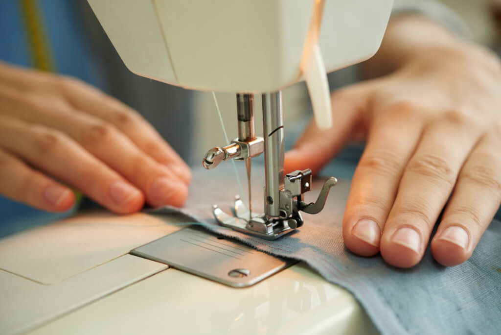 Pessoas criando costura de roupa em máquina