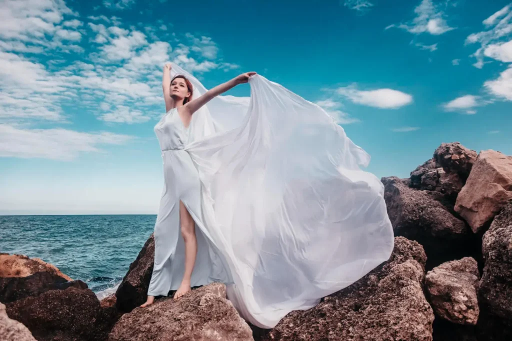 Color del año: mujer frente al mar con un vestido de color Cloud Dancer 