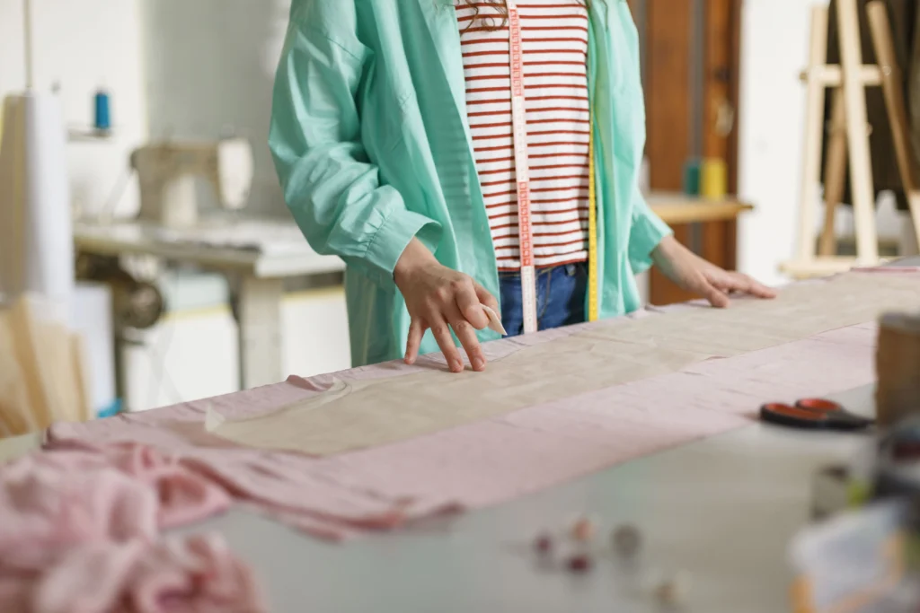 Mulher cortando moldes de roupa para costura