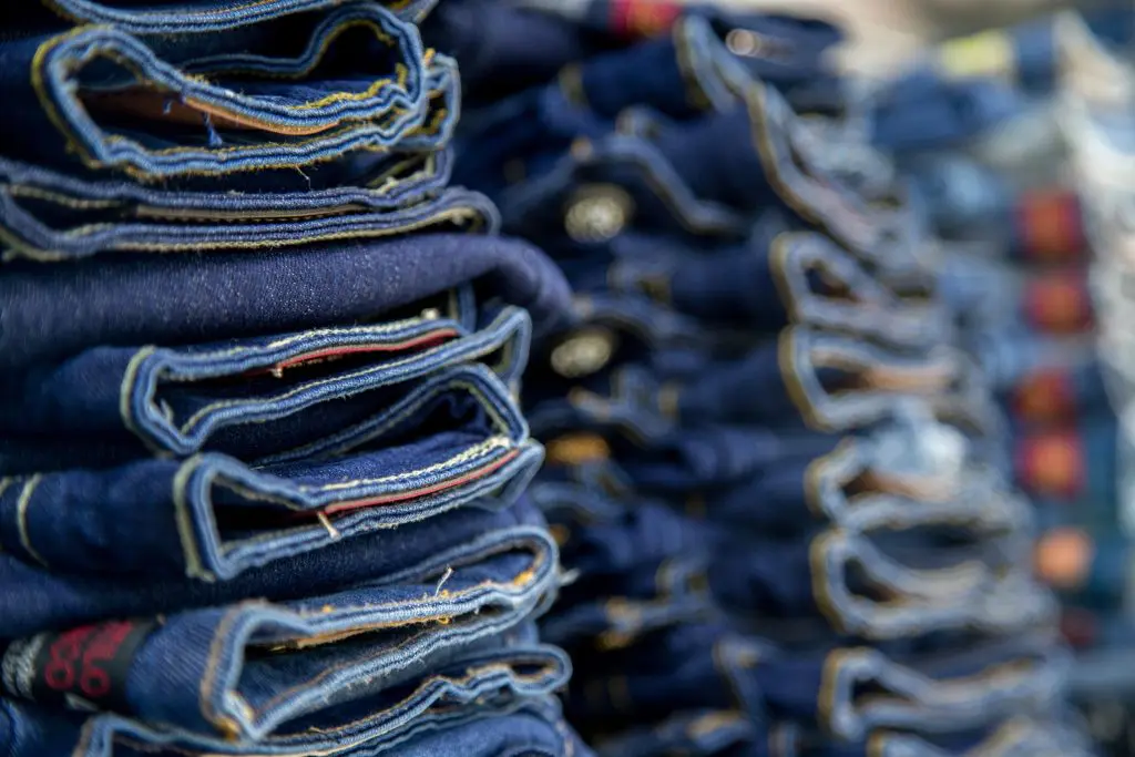 Several folded dark-wash denim jeans