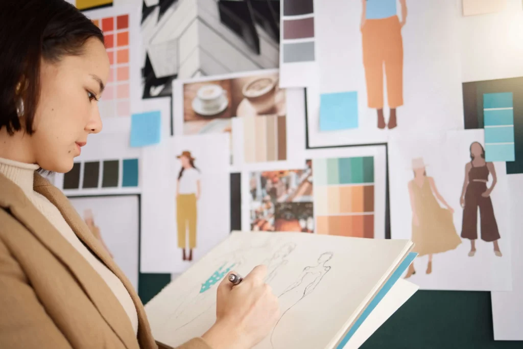 Woman drawing for a fashion mood board as a collection management step
