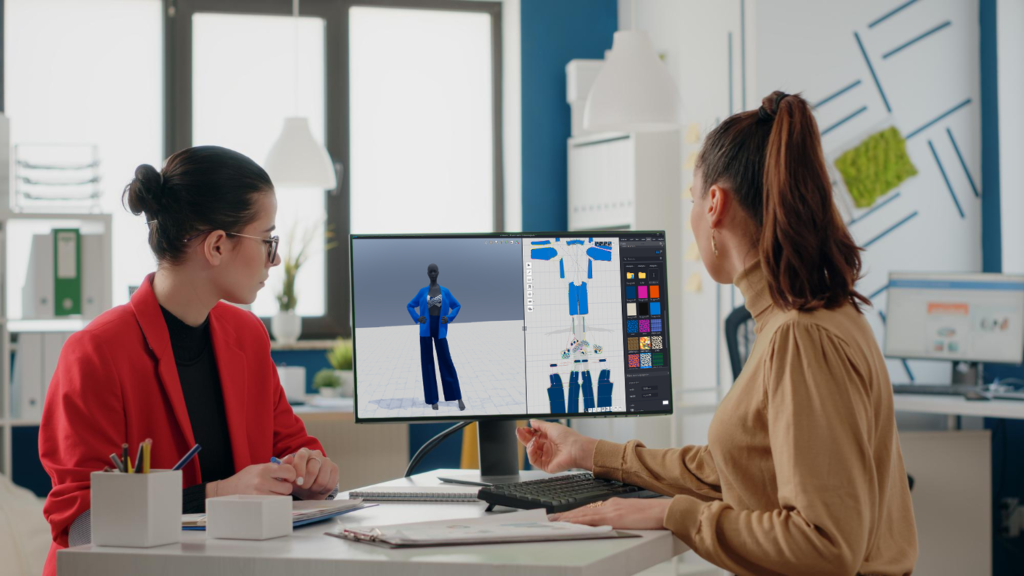 Two fashion designers in front of a computer screen using 3D modeling software to create.