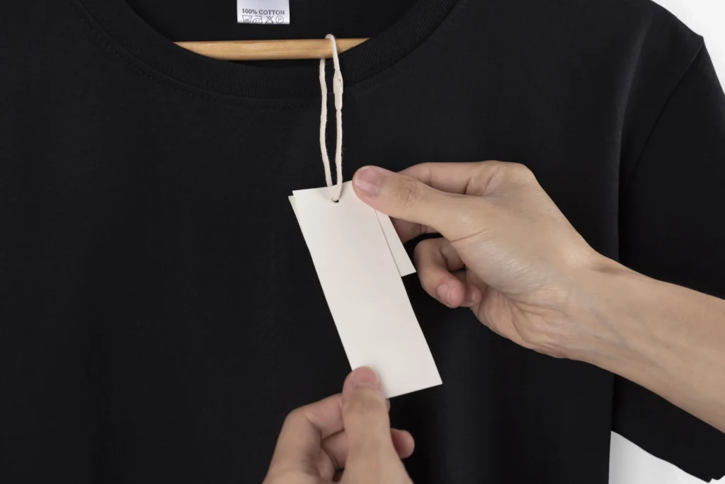 como precificar roupas: pessoa olhando etiqueta de preço de roupa 