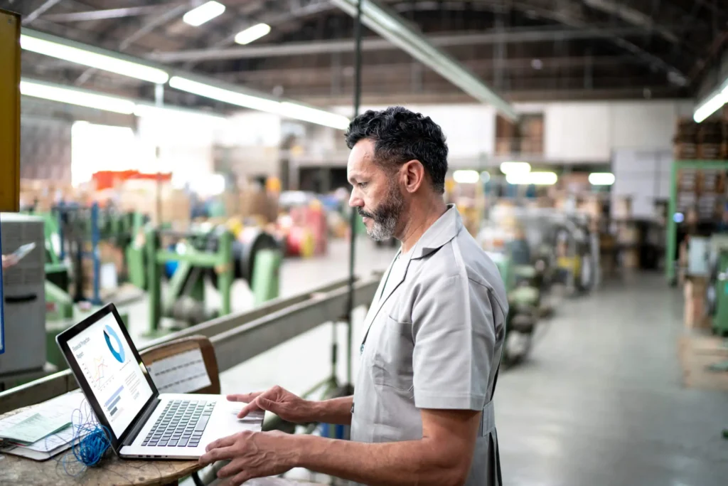 A man using a notebook to monitor PPC for manufacturing.