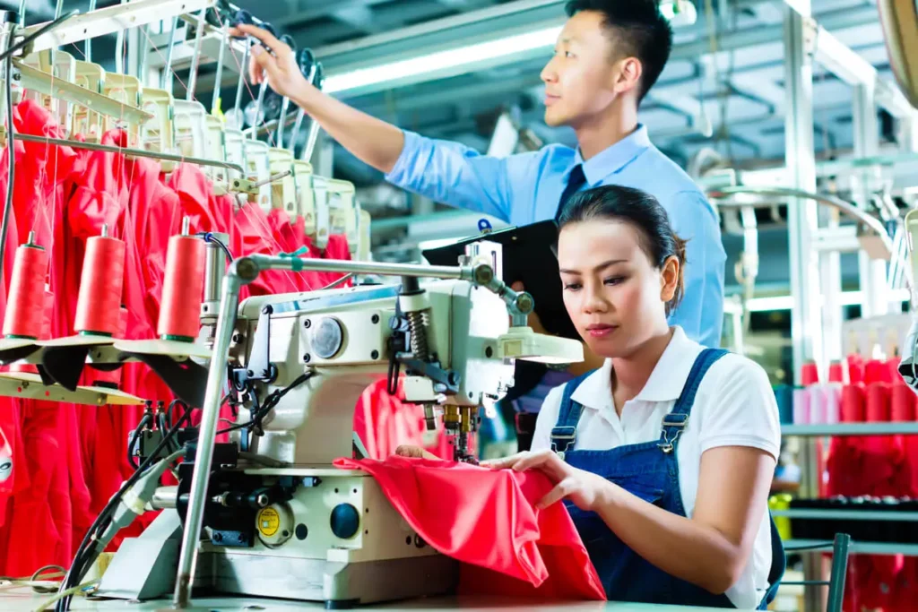 A seamstress and a fashion professional working with an efficient PPC for manufacturing.