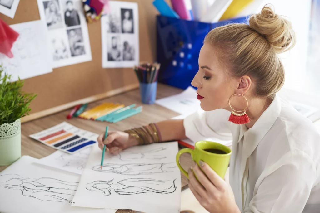 How to design a garment: a fashion designer sketching by hand using pencils.